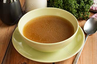 Bone broth made from beef, served in a green soup bowl