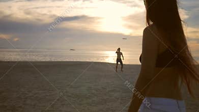 Carefree Friends Playing Flying Frisbee Disk on the Beach During Sunset. Koh Phangan, Thailand.