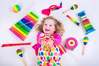 Adorable little girl with music instruments