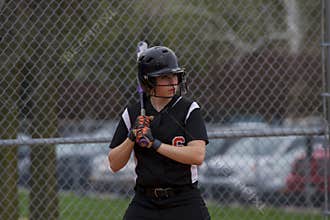 Female Fastpitch Softball Player In The Batters Box Sizing Up The Pitcher