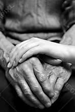 Hands of the old man and a young woman