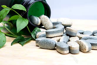 Herbal Supplement vitamin pills or tablets on wooden plate