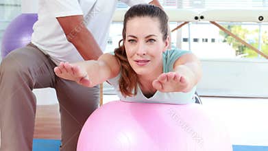 Physiotherapist using exercise ball with patient