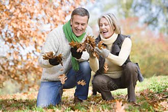Senior couple collecting autumn leaves