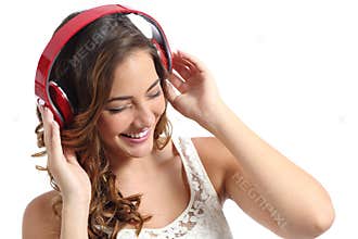 Young happy woman enjoying listening to the music from headphones