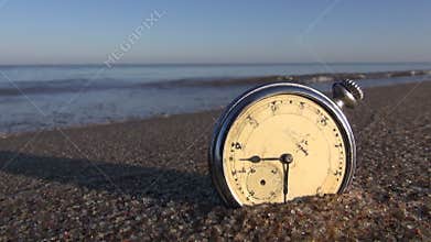 Analog pocket vintage clock on wet sea ocean resort beach sand