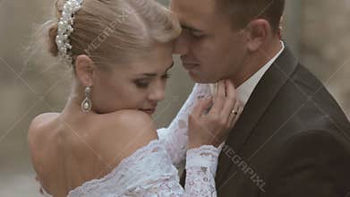 Bride and groom kissing near the walls of a castle