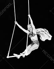 Portrait of a female circus performer performing on a trapeze bar