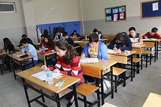 Group of high school students taking a test in classroom.