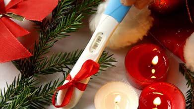 Pregnancy test positive result best present for parents and grandparents merry Christmas candles burning hand placing putting wait