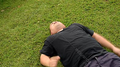 A fat bald head Asian Thai man is acting wriggling like a spoil child having seizures with angry aggressive face or having mental