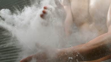 Sportsman clapping his hand with talc