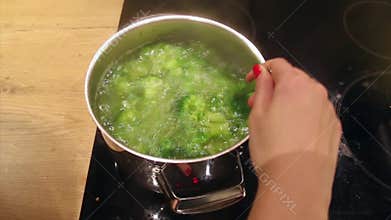 Potatoes and broccoli in boiling water in the kitchen