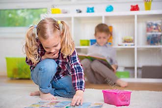 Cute little girl play game, boy read book