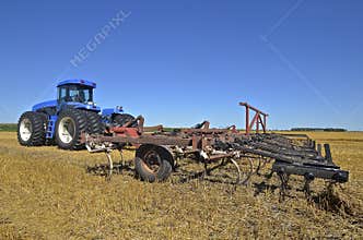 Huge tractor pulling a field cultivator