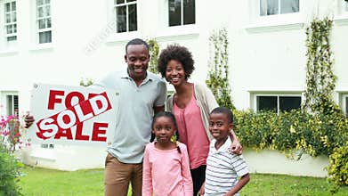 Happy family outside their new home