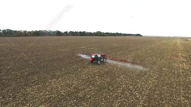 Red tractor plowing the field corn. aerial shot