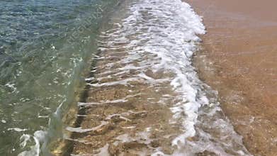 Ocean seascape scenic with waves crashing on sandy shore.