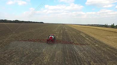 Tractor plowing the fields corn in spring. aerial