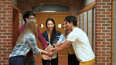 Happy students putting their hands together