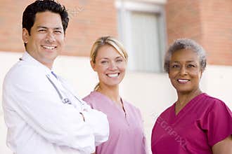 Doctor And Nurses Standing Outside A Hospital