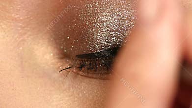 Model applying eyeliner closeup on eye, Close up
