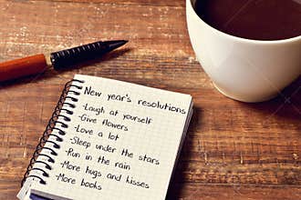 Coffee and notepad with a list of new years resolutions