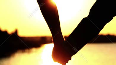 Father and Son Holding Hand At River Sunset, silhouettes