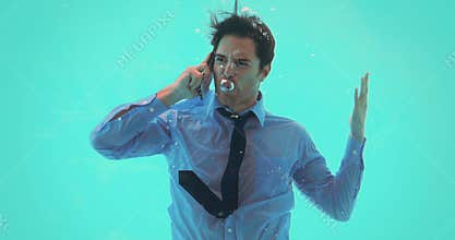 Businessman underwater talking on smartphone
