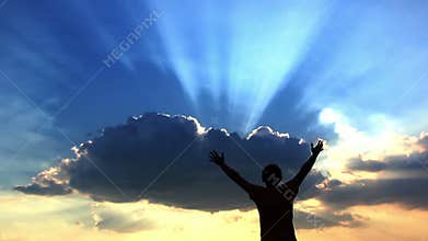 Silhouette man prays to God at dawn, man with his hands up at sunset