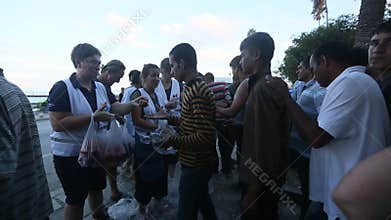 War refugees stand in a queue to receive humanitarian aid - water and apples.