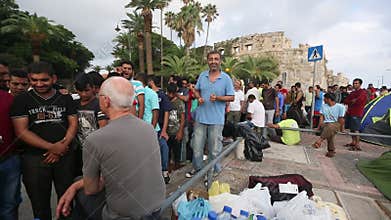 War refugees near tents on the sea waterfront. More than half are migrants from Syria