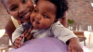 Mother holding her baby on exercise ball