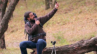 Man tourist with a backpack. Selfie in the forest.