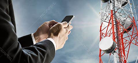 Businessman using mobile phone, with satellite dish telecom network on telecommunication tower on blue sky with sunshine