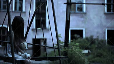 The ghost of a little girl on a swing in the old ruined house. evil spirit