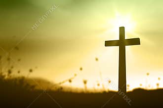 Christian Cross Silhouette In Golden Sunrise Light Over Peaceful Field