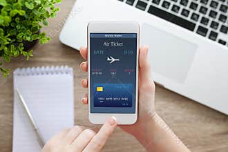 Female hand holding phone with online air ticket and notebook