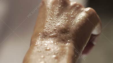 Water drops on skin in slow motion on a white bathtab background