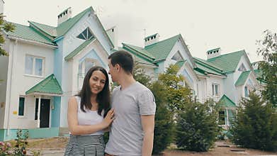 Young family in front of new house