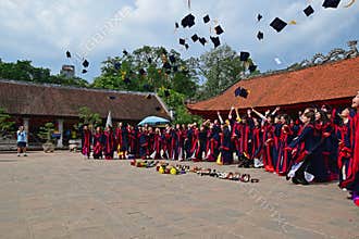 Students having graduation ceremony in Temple of Literature with hats up in the air