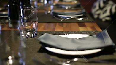 Glasses, forks, knives, plates on a table in restaurant served for dinner