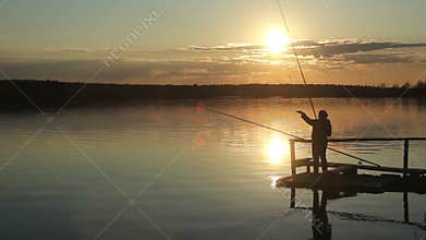 Silhouettes of fishermen at sunset of the sun.