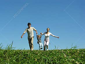 Family on herb under blue sky