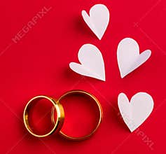 Wedding background - two gold wedding rings and handmade hearts