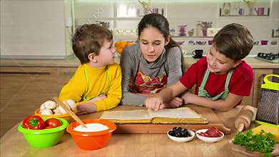 Three kids reading the cook book, making the dinner