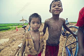Poor cambodian kids playing with bicycle