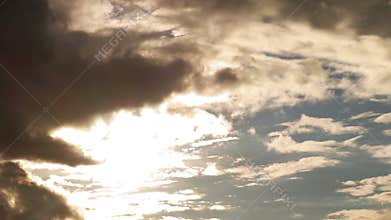 Dramatic storm clouds moving rapidly across the sky, covering the sun.
