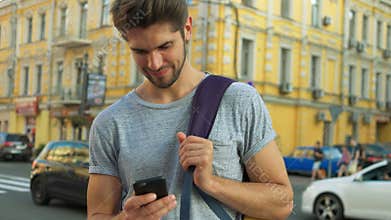 Tourist using his phone in the center of a city.