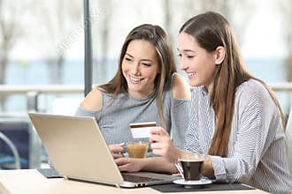 Two friends buying on line with a laptop